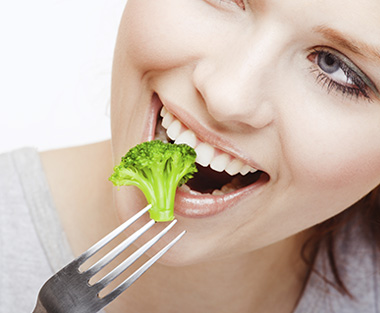 woman eating broccoli