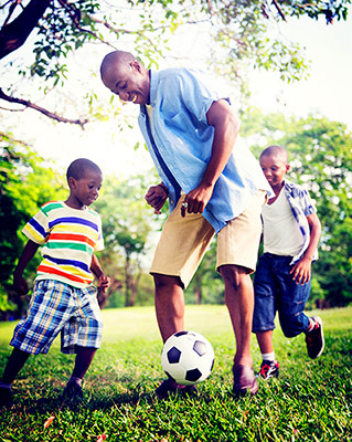 man playing soccer with kids