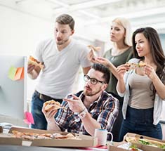 people eating pizza at office