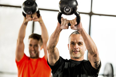 men workout out with kettlebells