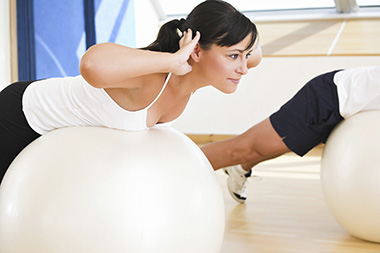 woman doing back exercises on a balance ball